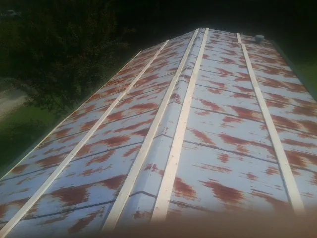 Rusted metal roof panels with new wood purlins before replacement — Storm Damage Roof Repair in Shannock by Roofing Brothers