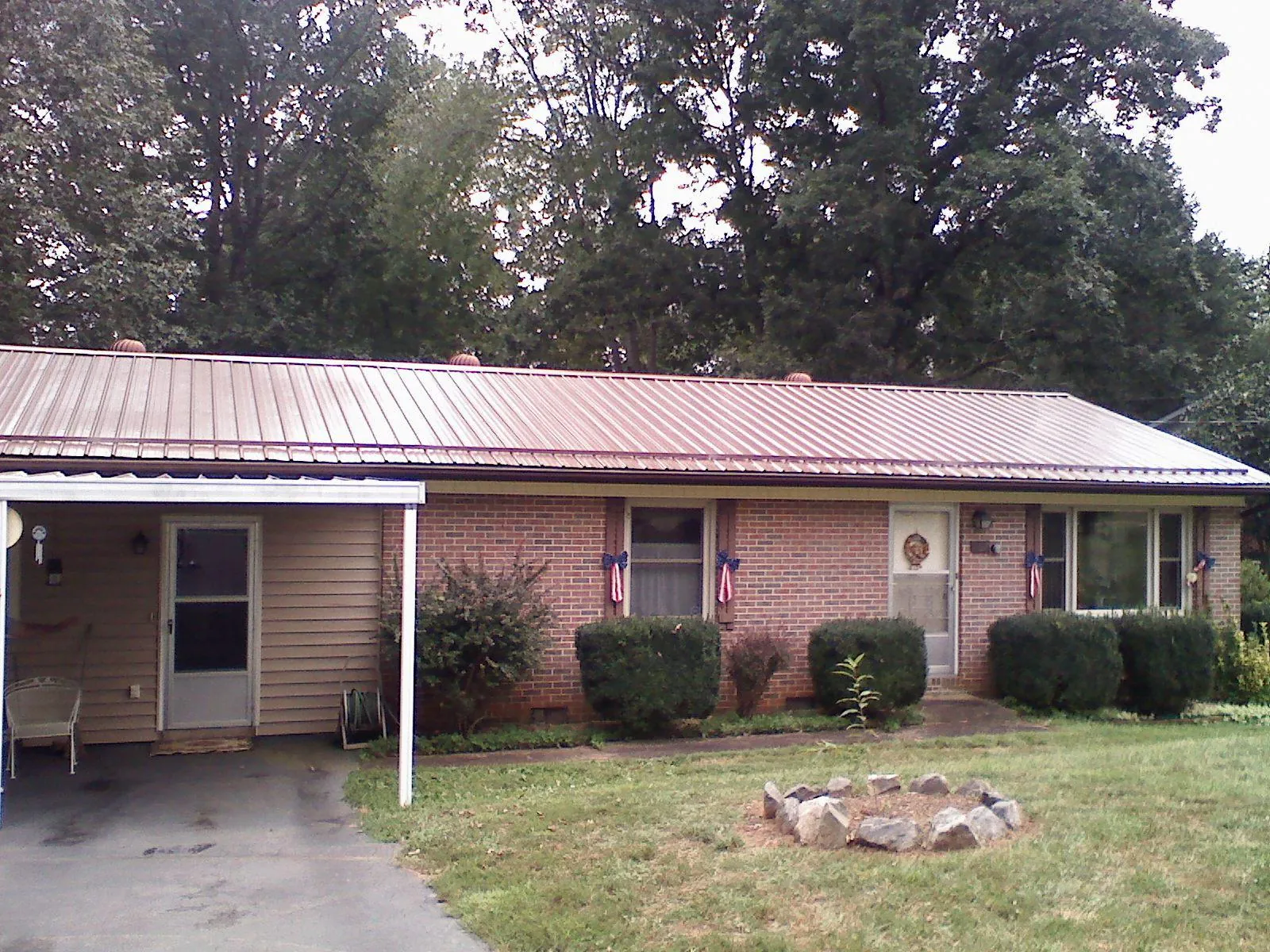 Bronze metal roof and carport on a brick ranch home — Roof Repair work by our crew in Shannock